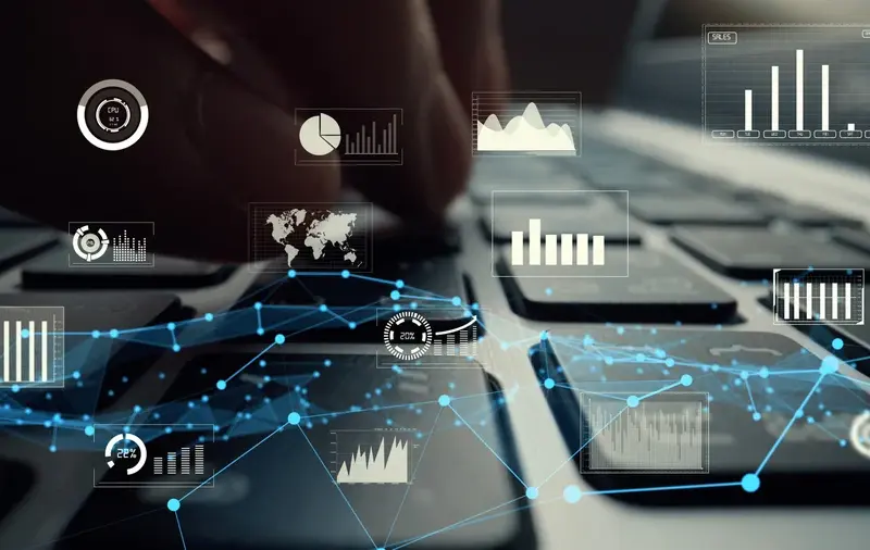 A close-up of fingers typing on a keyboard with digital data and analytics graphs overlaid, representing data analysis and technology.