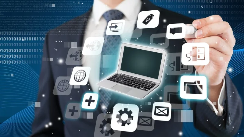 A person in a suit uses a marker to interact with floating digital icons and a laptop graphic, representing various technology and internet concepts.