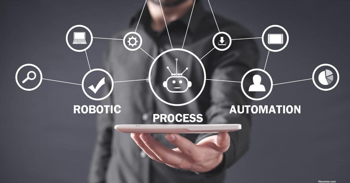 A person holds a tablet with icons and words "Robotic Process Automation" connected above it, representing business automation concepts.