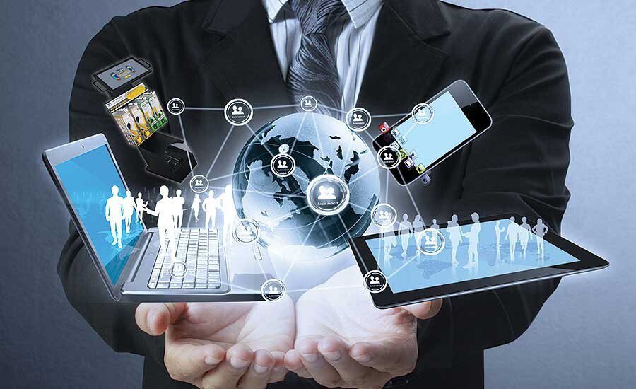 A person in a suit holds digital devices with holographic images of people, a globe, and network icons, symbolizing global digital connectivity and technology.