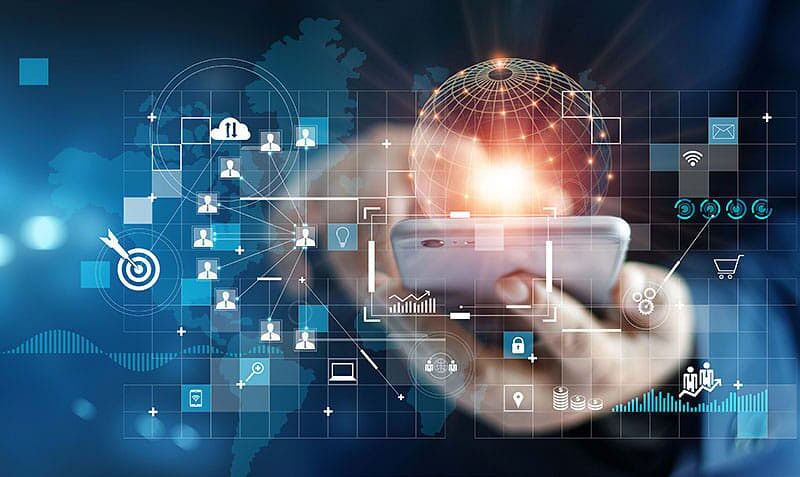 A person holds a smartphone with digital icons and global network graphics overlaying a world map, representing technology and connectivity.