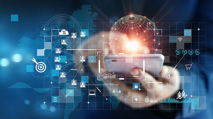 A person holds a smartphone with digital icons and global network graphics overlaying a world map, representing technology and connectivity.