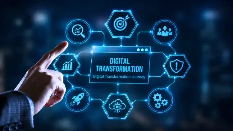 A hand points at a digital screen displaying “Digital Transformation” surrounded by icons representing business and technology concepts.